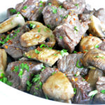 Air Fryer Steak and Mushrooms in a white bowl topped off with parsley.