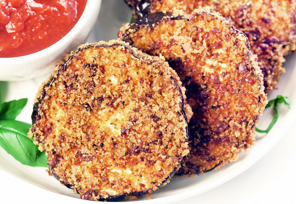 Air Fryer Eggplant Chips being dipped into a bowl of marinara sauce.