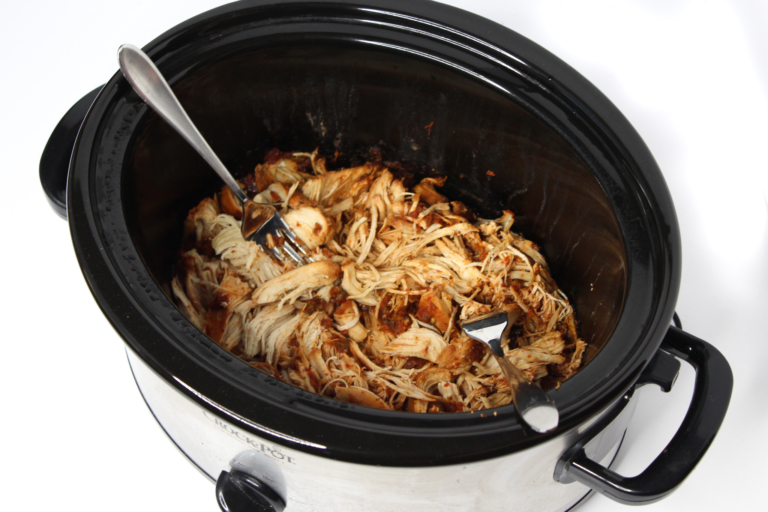 Shredded Chicken and 2 forks in black slow cooker