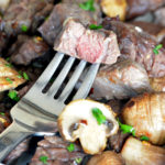 A bite of Air Fryer Steak on a fork mixed with mushrooms.