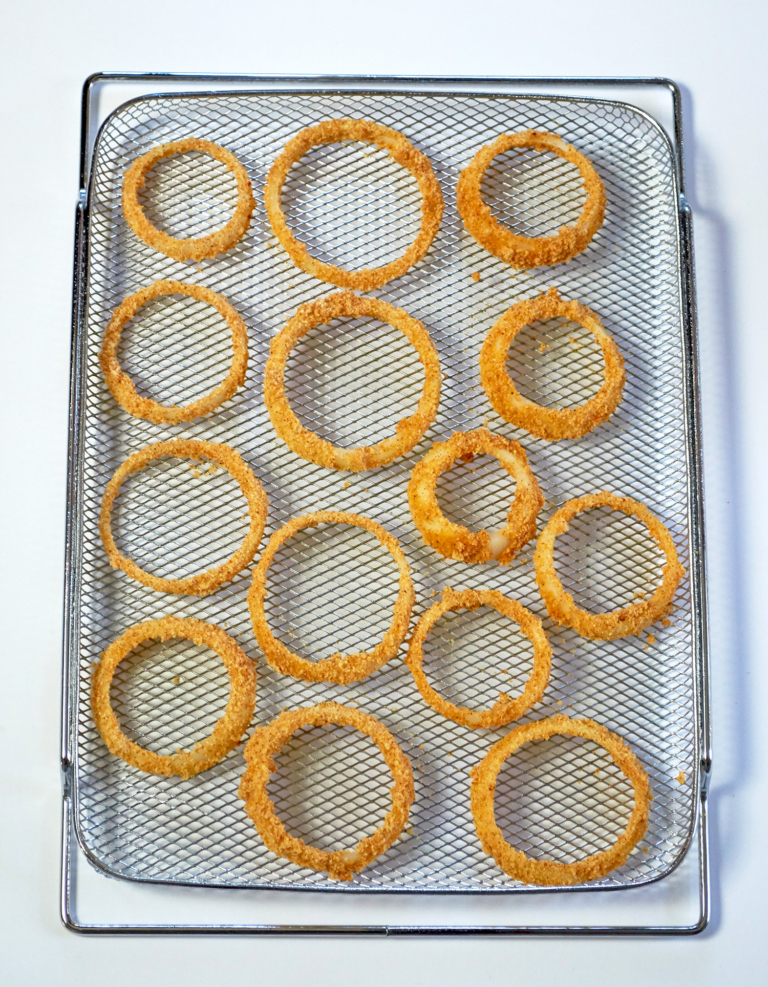 Breaded onion rings on an air fryer baking tray.