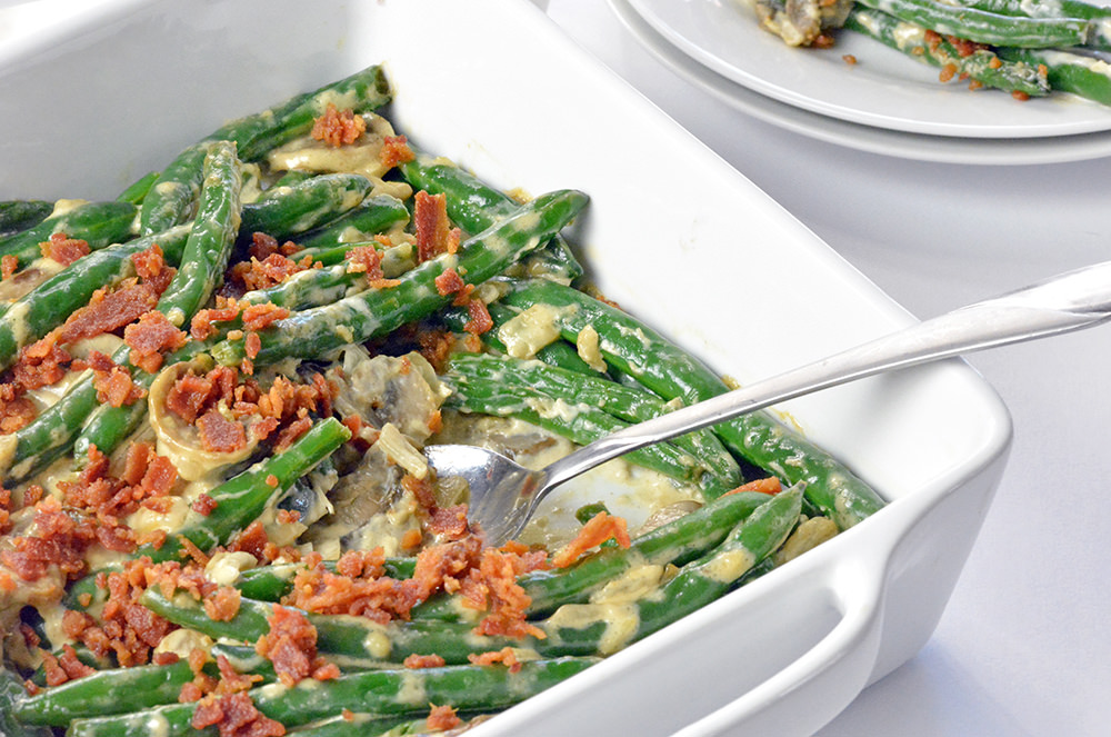 Green Bean Casserole in a white baking dish and silver spoon.