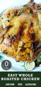 Whole chicken on a white plate surrounded by lemon, onion and herbs.