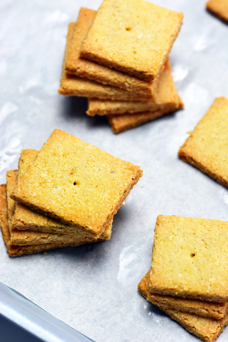 Baked Keto Crackers on parchment paper lined silver baking sheet.