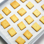 Baked Keto Crackers on parchment paper lined silver baking sheet.