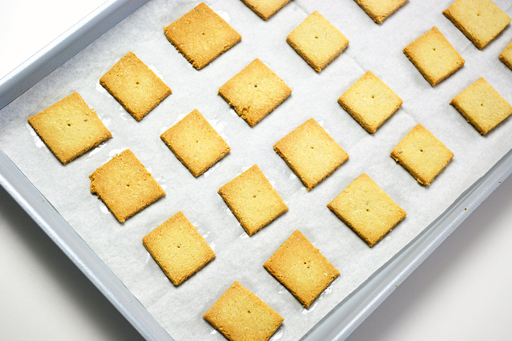 Baked Keto Crackers on parchment paper lined silver baking sheet.