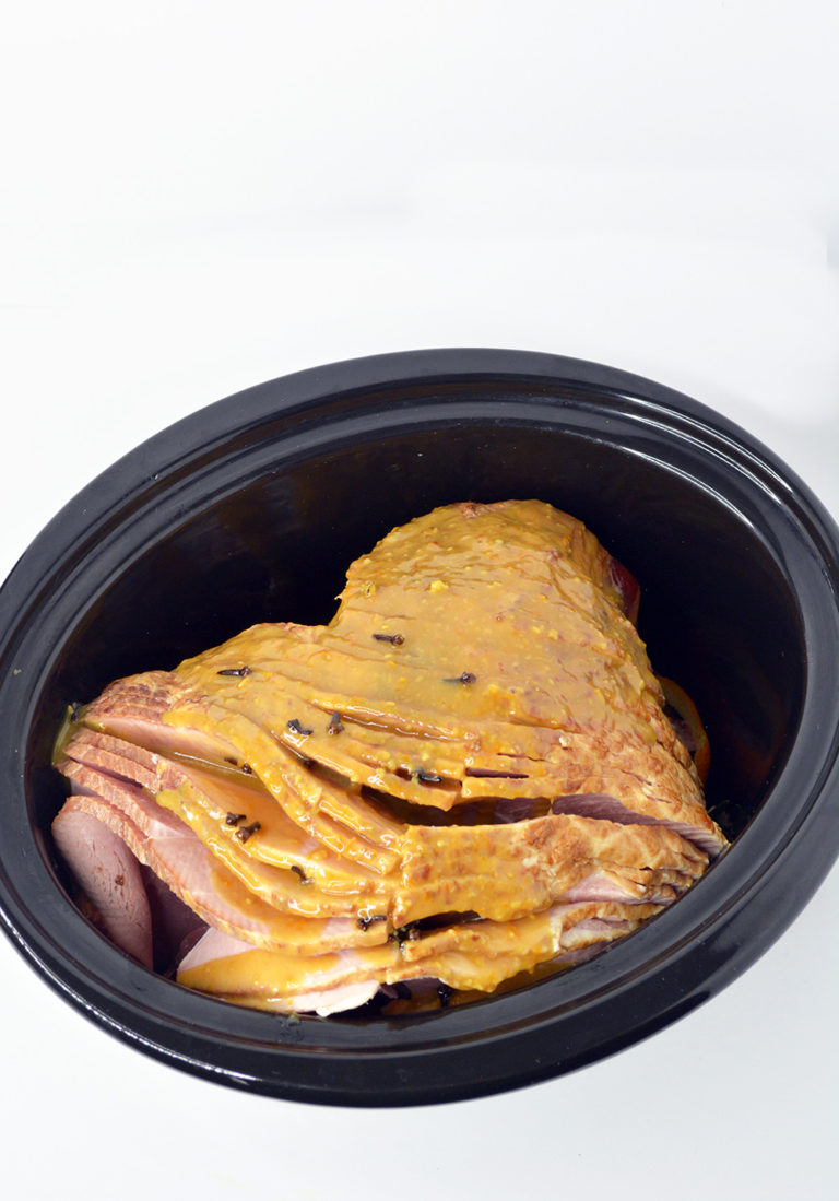 Uncooked Crockpot Ham in a black crockpot.