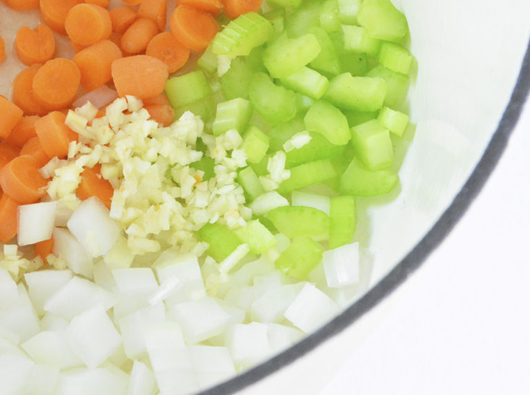 Chopped carrots, celery, onions and minced garlic in a cream dutch oven.