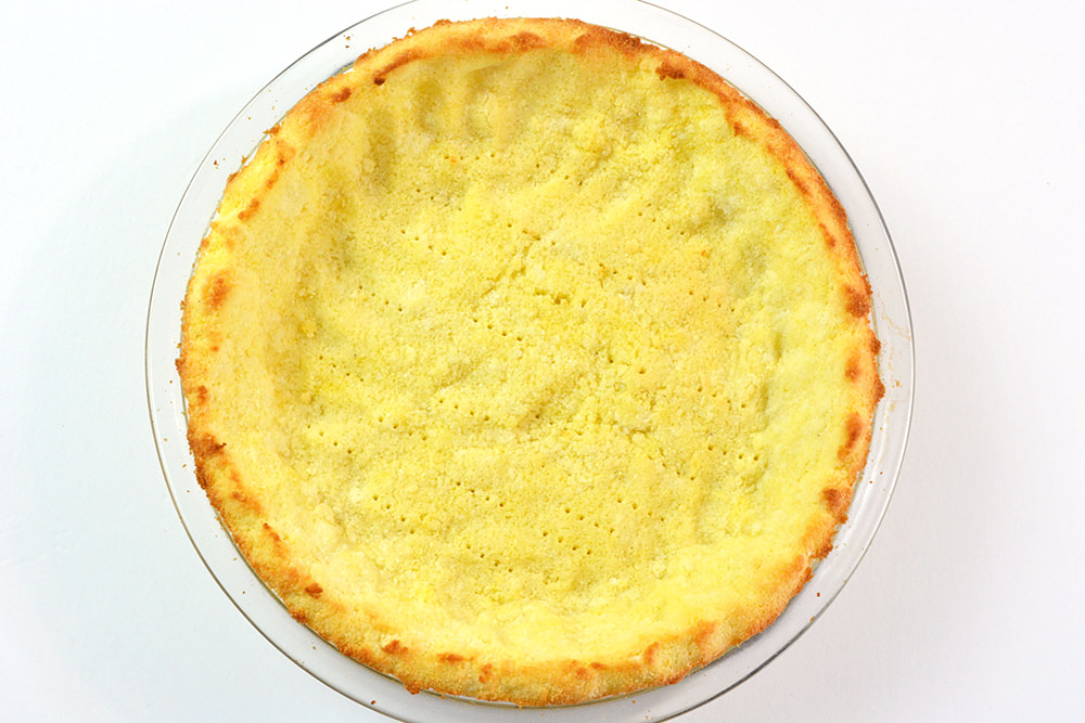 Baked Keto pie crust in a clear pie tin.