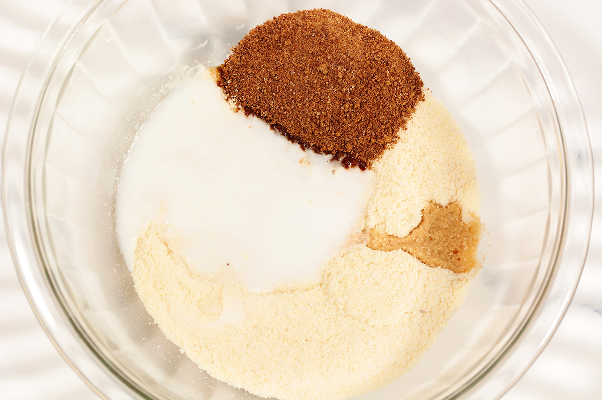 Almond flour, coconut flour, melted coconut oil, golden monk fruit sweater, piled in a glass bowl.