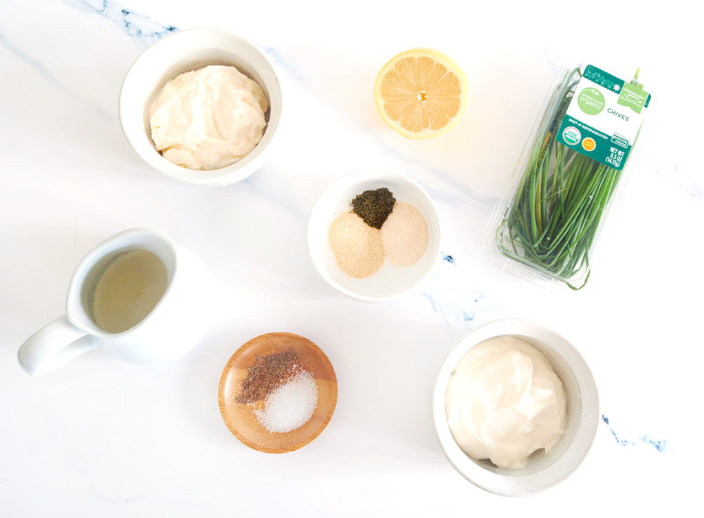 All the ingredients to make ranch dressing at home. Mayo, sour cream, heavy cream, chives and seasoning.