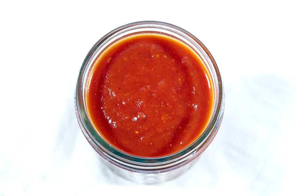 Top down view of whole30 bbbq sauce in a large glass mason jar.